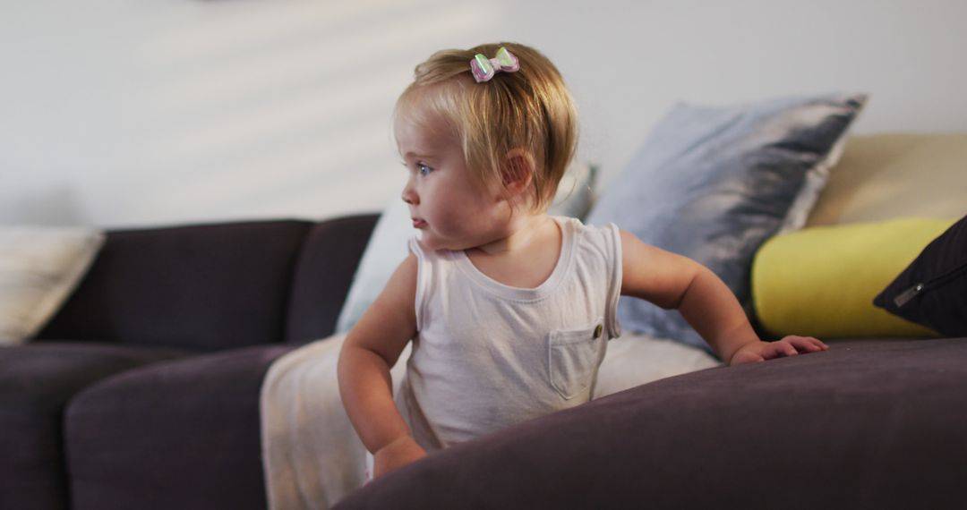 Cute caucasian baby standing while holding the couch at home - Free Images, Stock Photos and Pictures on Pikwizard.com