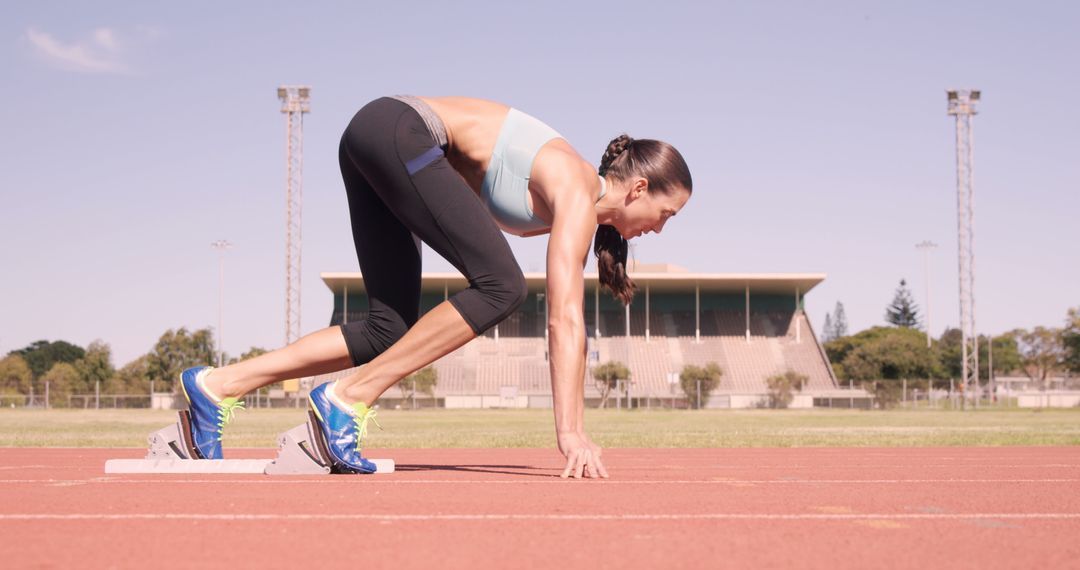 Female Athlete Preparing to Sprint on Athletics Track - Free Images, Stock Photos and Pictures on Pikwizard.com