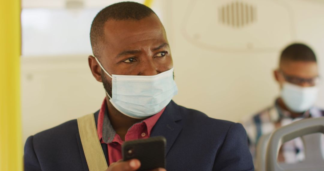 Man in Suit Using Smartphone on City Bus During Pandemic