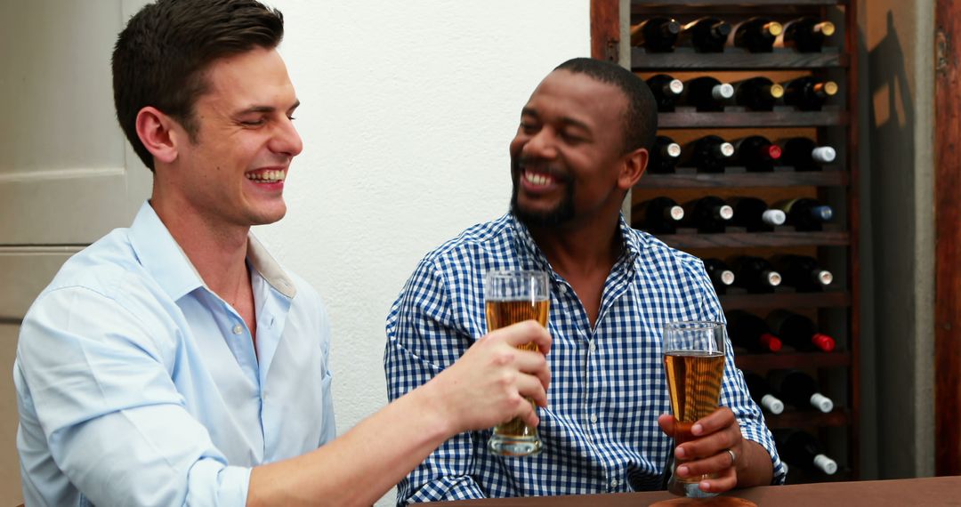 Two Friends Toasting with Beer in Casual Setting - Free Images, Stock Photos and Pictures on Pikwizard.com