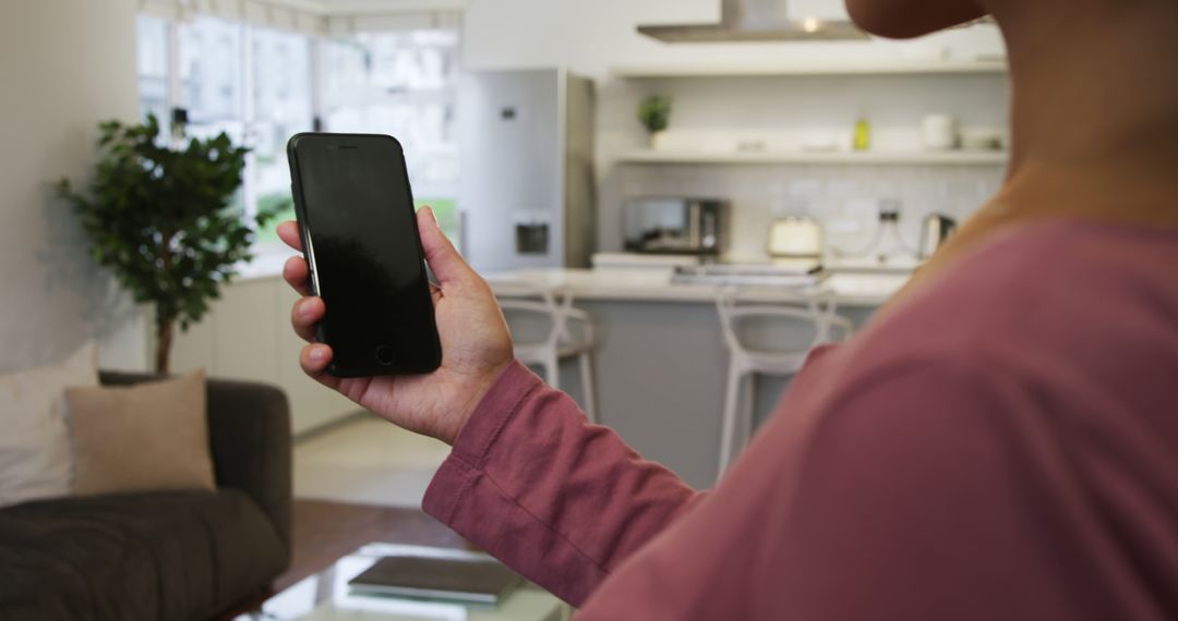 Person Holding Smartphone in Modern Kitchen Interior - Free Images, Stock Photos and Pictures on Pikwizard.com