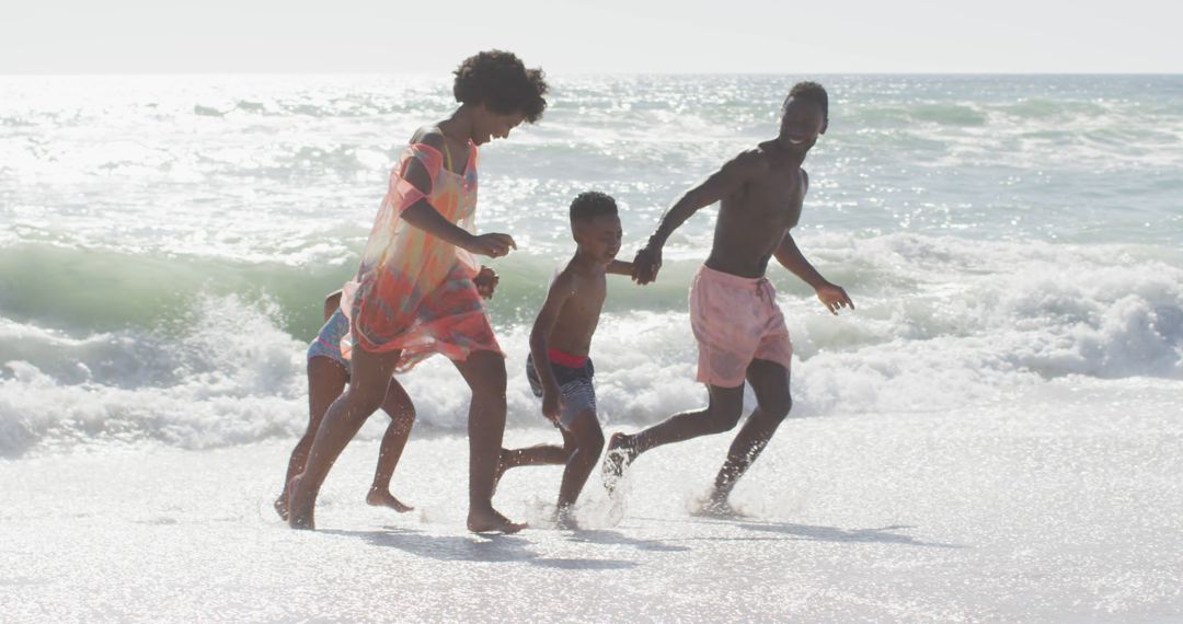 Joyful Family Running on Sandy Beach by the Ocean Waves - Free Images, Stock Photos and Pictures on Pikwizard.com