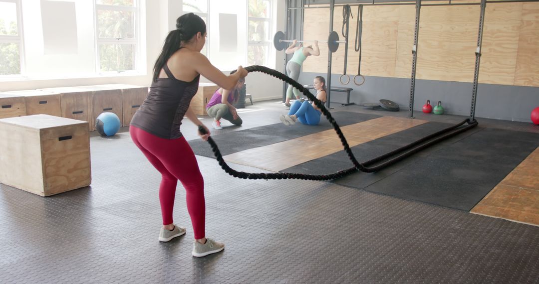 People Exercising with Battle Ropes and Equipment in Modern CrossFit Gym - Free Images, Stock Photos and Pictures on Pikwizard.com