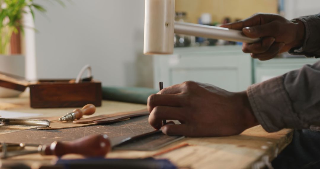 Artisan Crafting Leather with Hand Tools in Workshop Setting