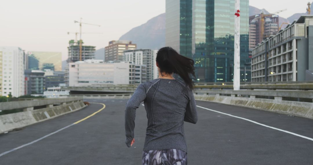 Female runner exercising on urban rooftop at sunrise - Free Images, Stock Photos and Pictures on Pikwizard.com