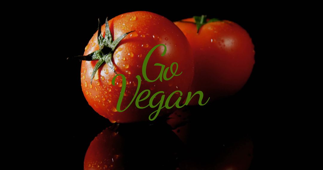 Go Vegan Text Over Ripe Red Tomatoes with Black Background