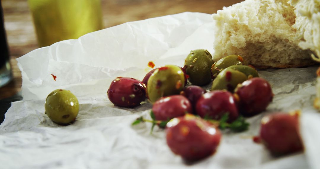 Close-up of Marinated Olives and Fresh Bread on Parchment Paper - Free Images, Stock Photos and Pictures on Pikwizard.com