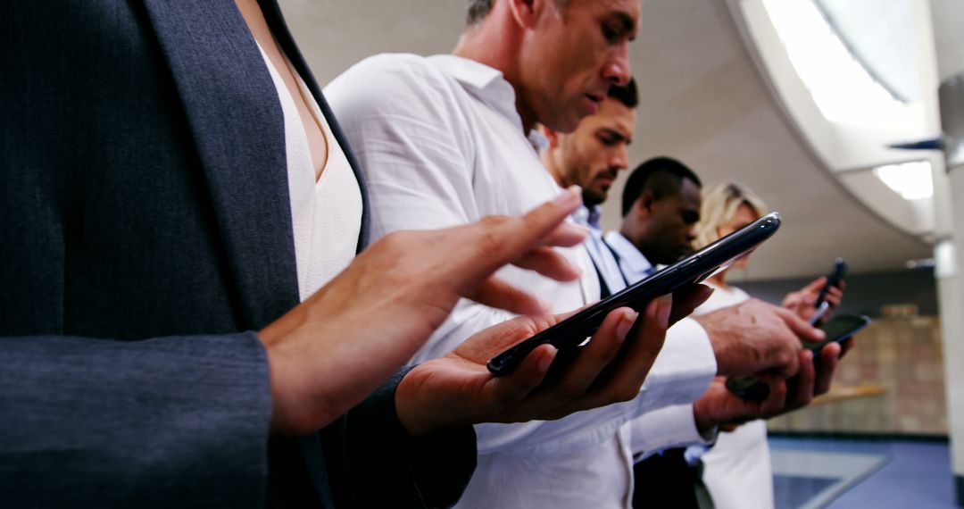 Diverse Group of Adults Focused on Smartphones in Modern Setting