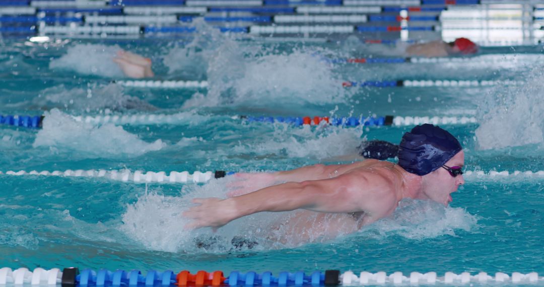 Competitive Swimmer in Butterfly Stroke during Race in Pool - Free Images, Stock Photos and Pictures on Pikwizard.com