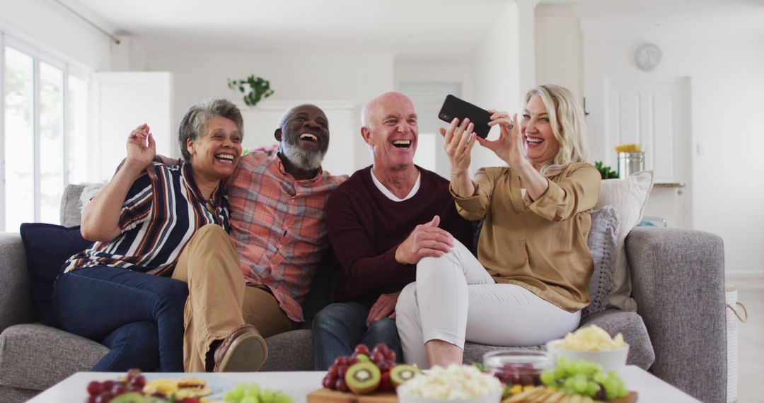 Happy seniors taking selfies together on a sofa in living room - Free Images, Stock Photos and Pictures on Pikwizard.com