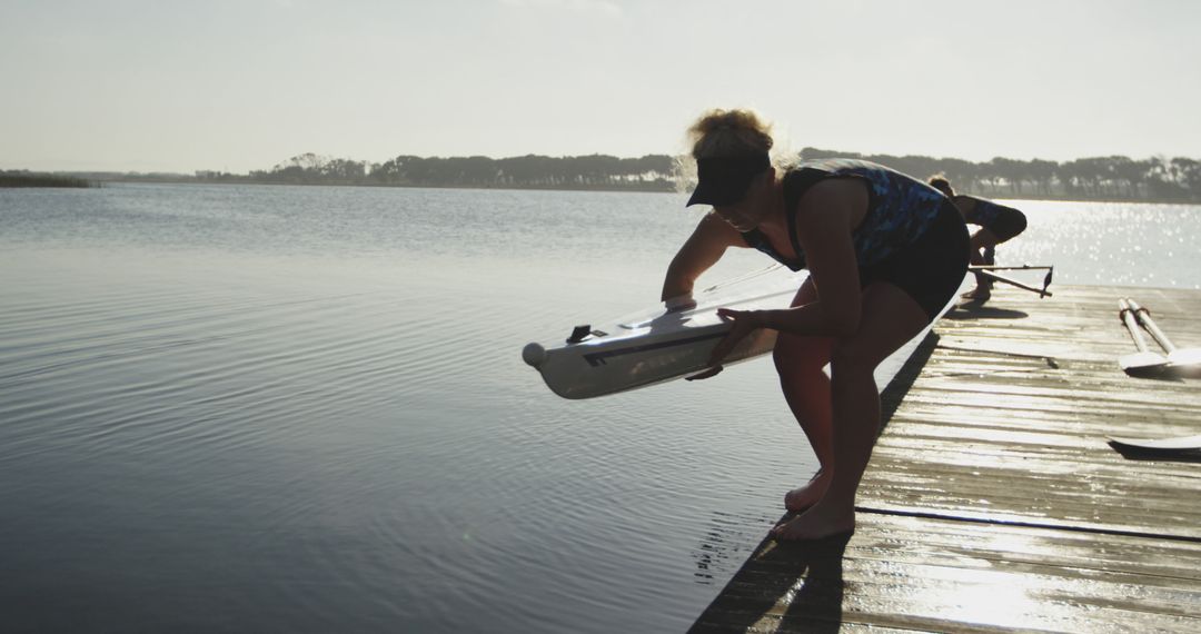 Person Preparing Kayak on Calm Lake at Sunrise - Free Images, Stock Photos and Pictures on Pikwizard.com