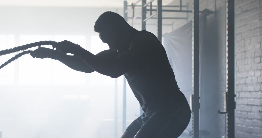 Man Exercising with Battle Ropes in Gym for Strength