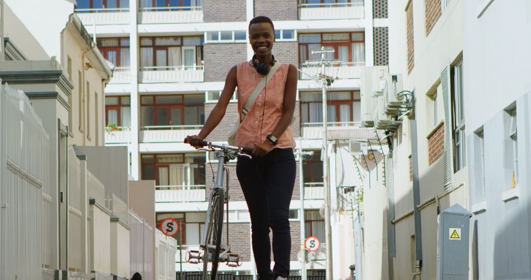 Urban woman riding bicycle in city street with smile - Free Images, Stock Photos and Pictures on Pikwizard.com