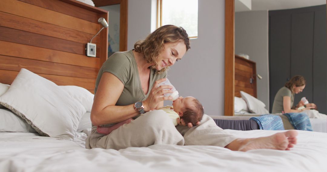 Image of happy caucasian mother feeding newborn baby with bottle on bed - Free Images, Stock Photos and Pictures on Pikwizard.com