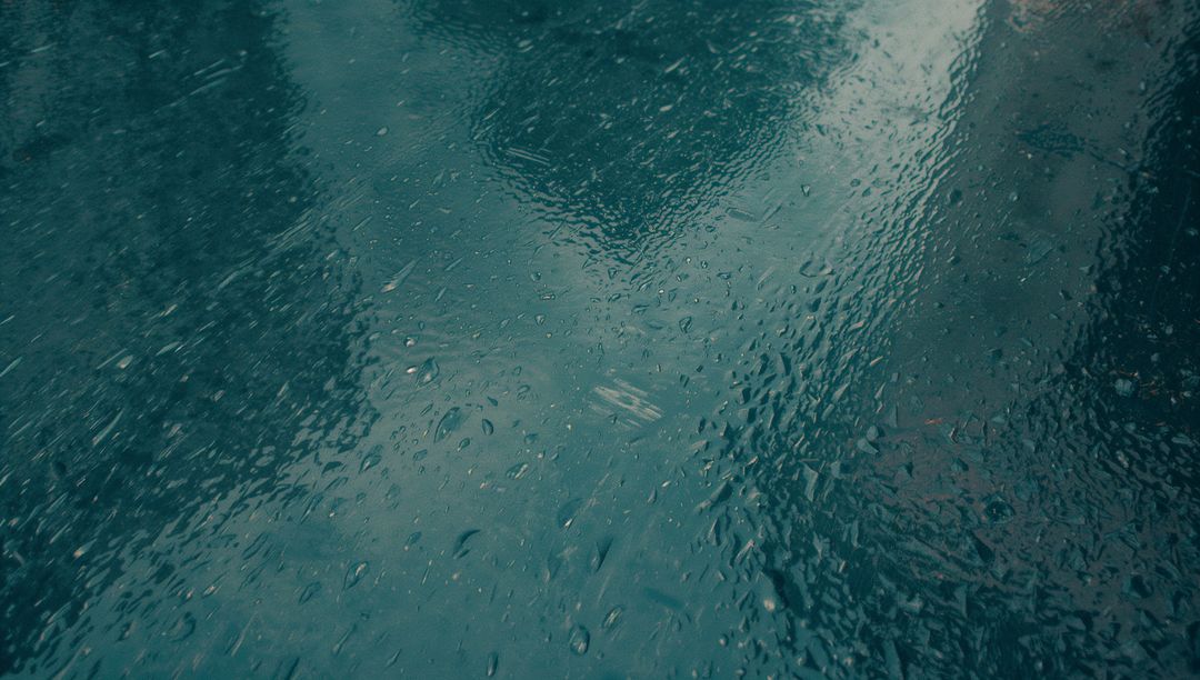 Moody Wet Glass Reflecting Urban Skyline with Raindrops