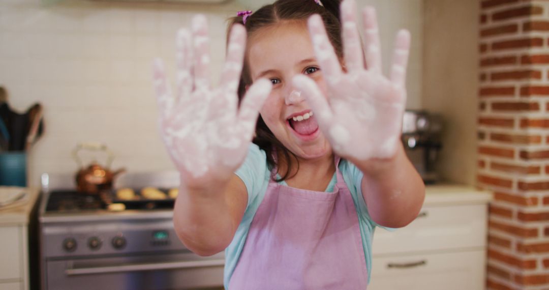 Happy Girl Baking and Showing Floury Hands in Kitchen - Free Images, Stock Photos and Pictures on Pikwizard.com