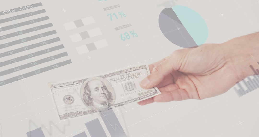 Hand Holding Dollar Bill with Business Graphs and Statistics Background