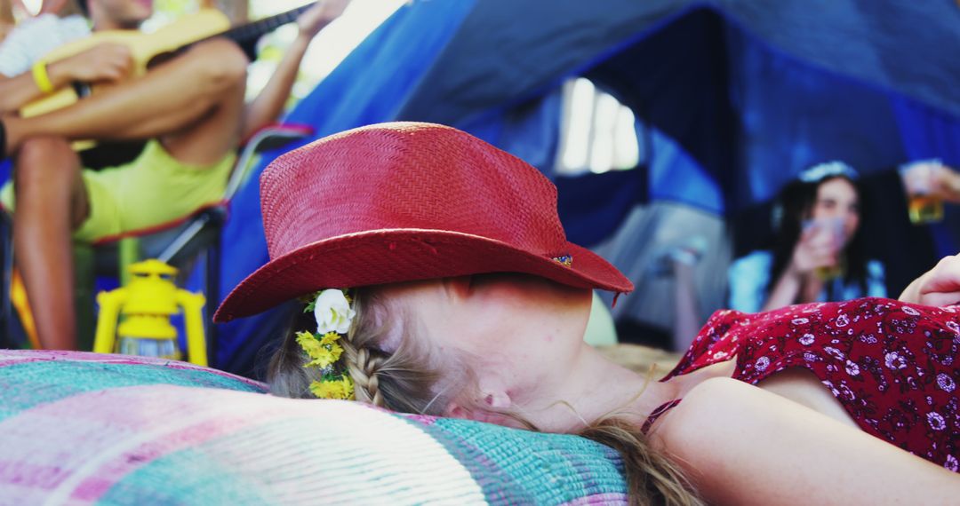 Festival Goers Relaxing near Tent with Red Hat - Free Images, Stock Photos and Pictures on Pikwizard.com