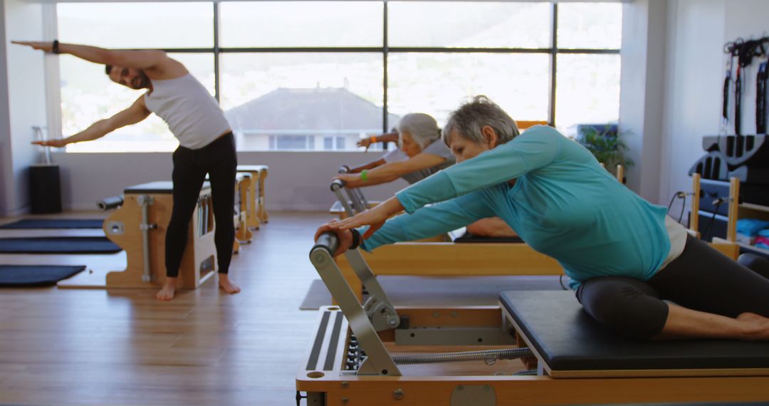 Seniors Practicing Pilates in Modern Fitness Studio - Free Images, Stock Photos and Pictures on Pikwizard.com