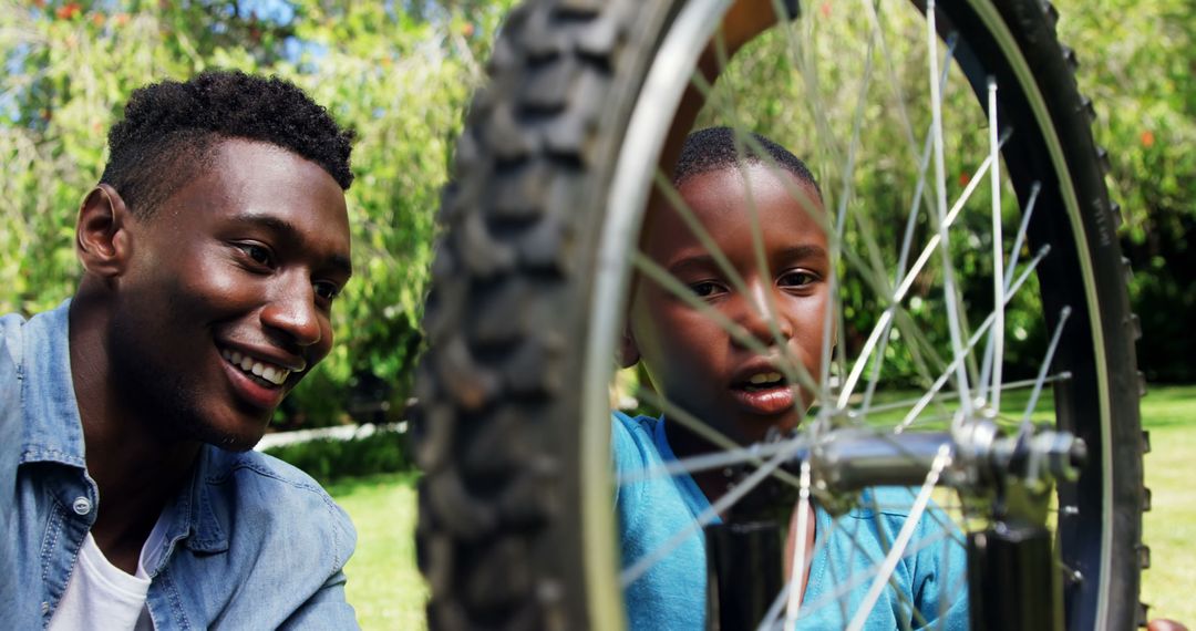 Father and son repairing bicycle together in park - Free Images, Stock Photos and Pictures on Pikwizard.com