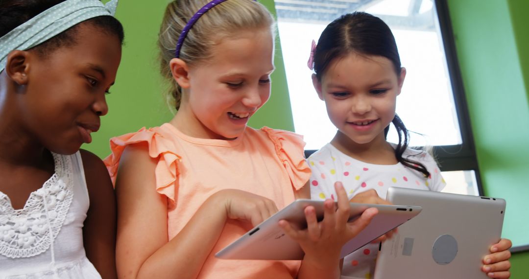 Smiling Schoolgirls Enjoying Learning with Tablets in Classroom