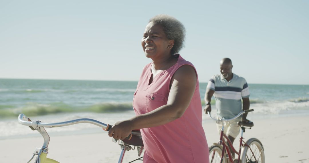 Senior African American Couple Riding Bicycles on Beach - Free Images, Stock Photos and Pictures on Pikwizard.com