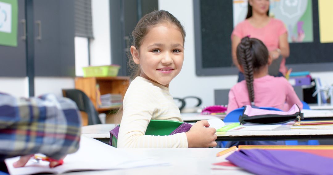 Smiling Girl Sitting in Classroom Holding Book