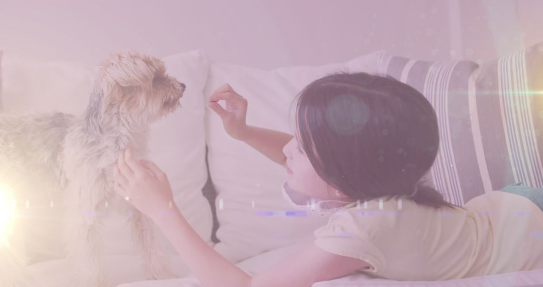 Young Girl Playing with Her Dog on Couch at Home in Soft Lighting
