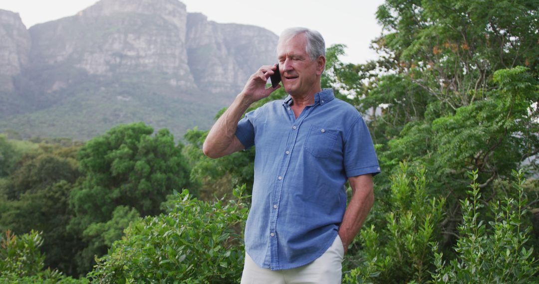 Senior Man Talking on Mobile Phone in Scenic Mountain Landscape - Free Images, Stock Photos and Pictures on Pikwizard.com