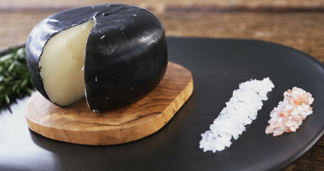 Black Wax Cheese Wheel with Assorted Salts on Elegant Dining Plate - Free Images, Stock Photos and Pictures on Pikwizard.com