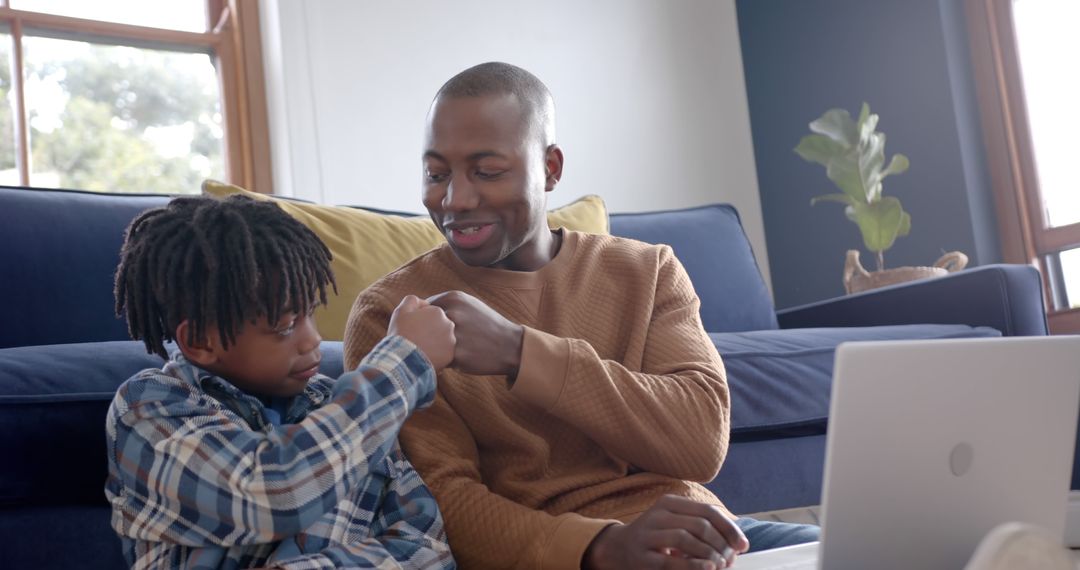 African American father and son spending quality time at home using laptop - Free Images, Stock Photos and Pictures on Pikwizard.com