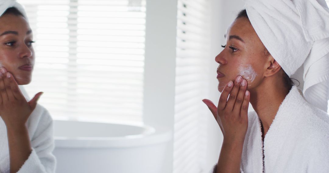 Woman Applying Face Cream While Looking in Mirror - Free Images, Stock Photos and Pictures on Pikwizard.com