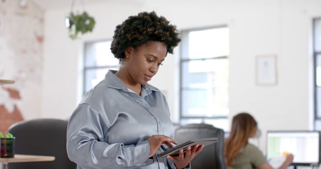 African American Businesswoman Using Tablet in Modern Office - Free Images, Stock Photos and Pictures on Pikwizard.com