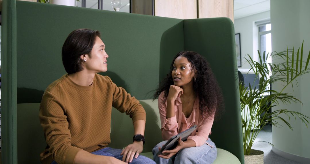 Diverse Coworkers Discussing Project in Modern Office Lounge