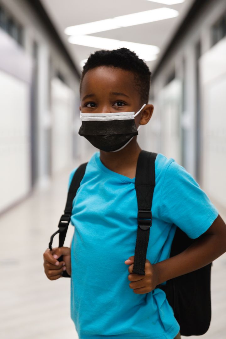 Young African American Boy Wearing Mask with Backpack in School Hallway - Free Images, Stock Photos and Pictures on Pikwizard.com