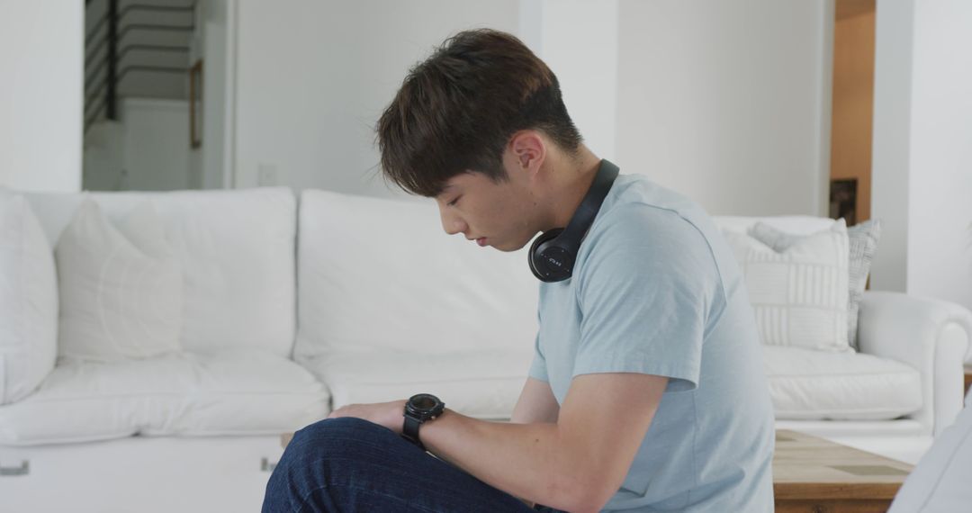 Young Man Relaxing with Headphones in Modern Living Room - Free Images, Stock Photos and Pictures on Pikwizard.com