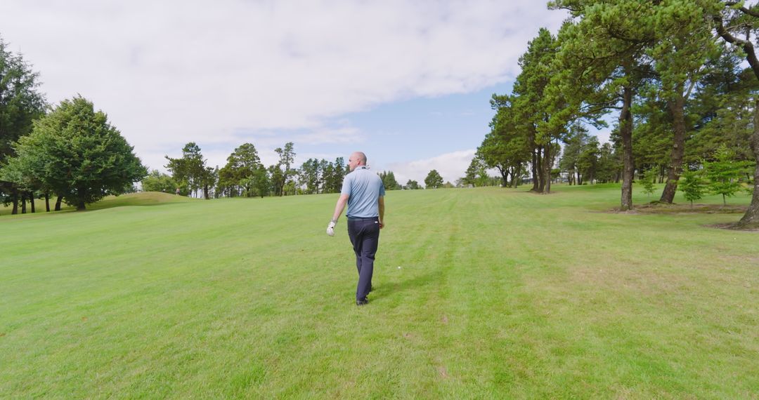 Senior Golfer Strolling Through Scenic Fairway on Sunny Day