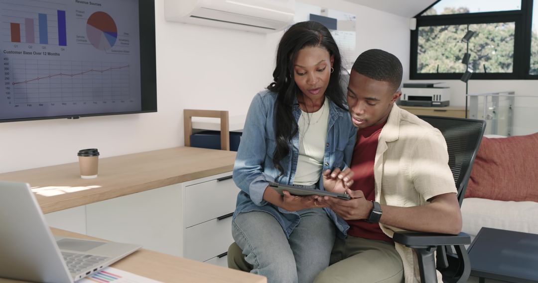 Coworkers Collaborating with Tablet Analyzing Data in Modern Office