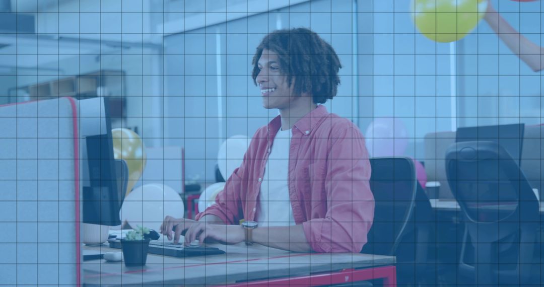 Young Professional Typing at Festive Open-Plan Office Desk with Balloons and Succulent