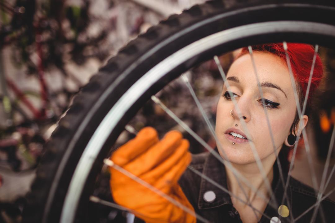 Female Mechanic Inspecting Bicycle Wheel - Free Images, Stock Photos and Pictures on Pikwizard.com