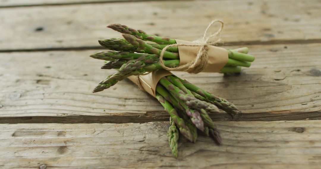 Image of two fresh asparagus bundles on wooden background - Free Images, Stock Photos and Pictures on Pikwizard.com