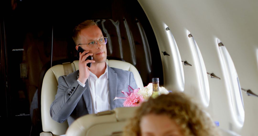 Businessman Talking on Phone in Private Jet - Free Images, Stock Photos and Pictures on Pikwizard.com