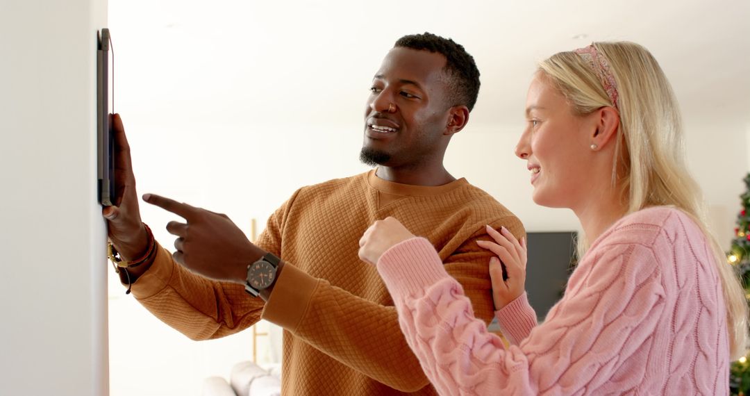 Diverse Couple Using Touchscreen Panel in High-Tech Home