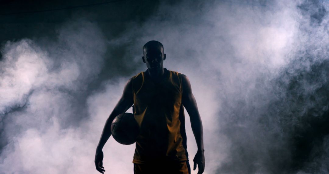 Silhouette of basketball player standing in mist - Free Images, Stock Photos and Pictures on Pikwizard.com