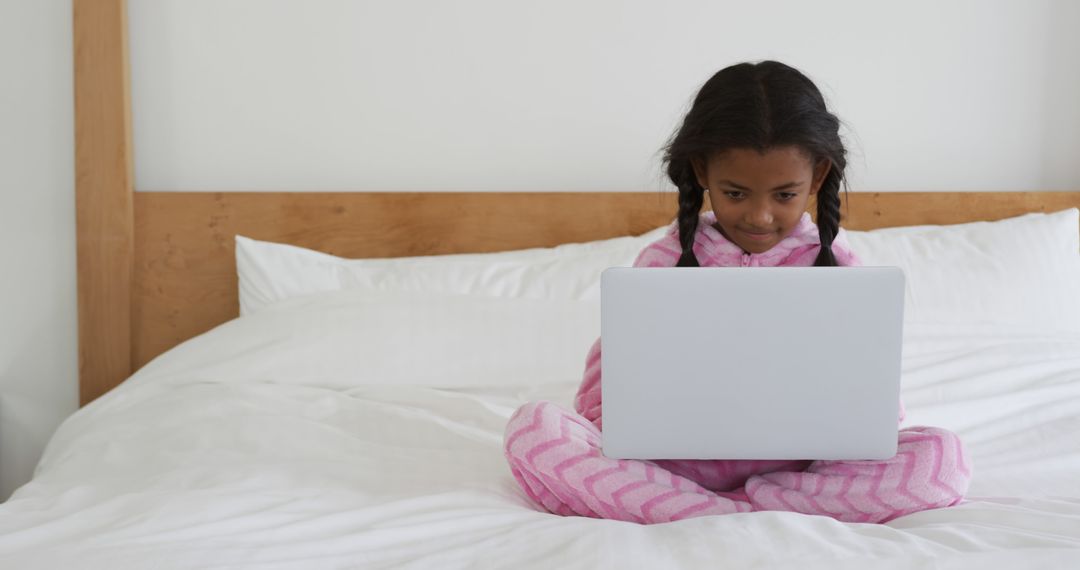 Young Girl in Pajamas Using Laptop on Bed - Free Images, Stock Photos and Pictures on Pikwizard.com