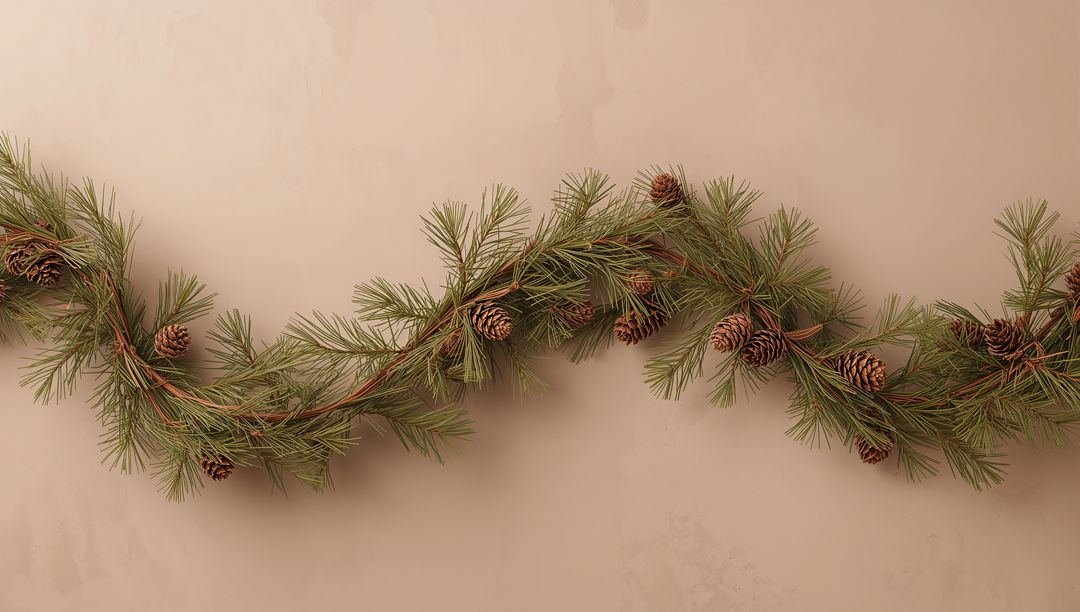 Minimal pine cone garland draping across warm beige wall with natural evergreen needles