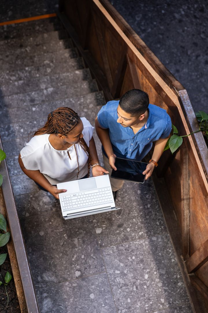 Diverse Coworkers Engaging with Digital Technology in Urban Setting