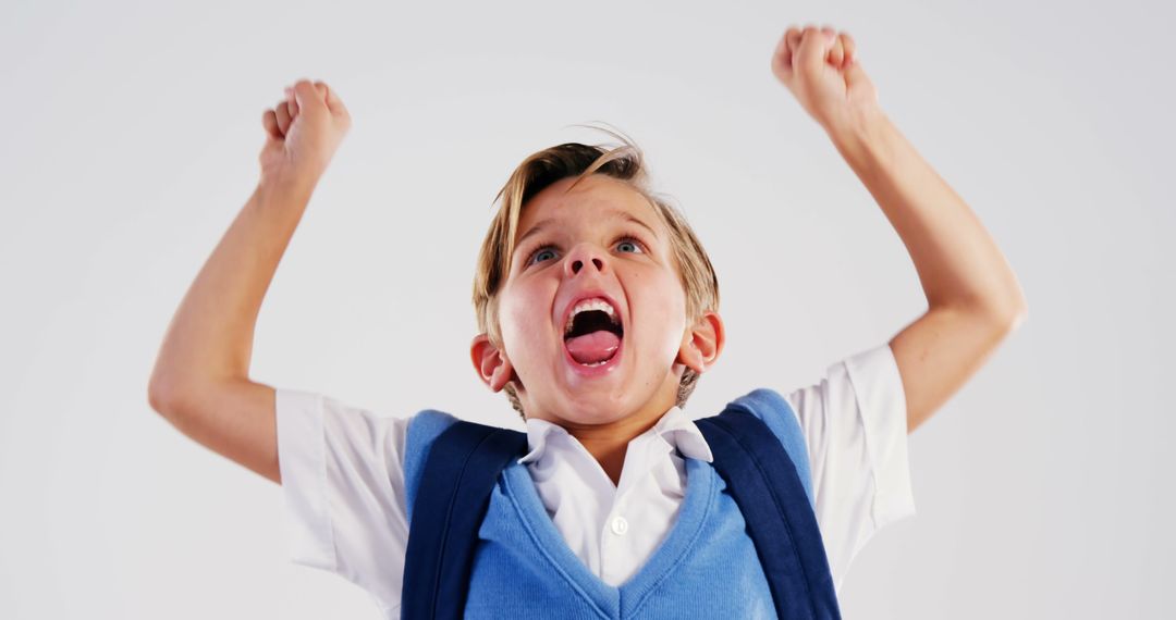 Excited Young Boy Celebrating Success with Raised Arms - Free Images, Stock Photos and Pictures on Pikwizard.com