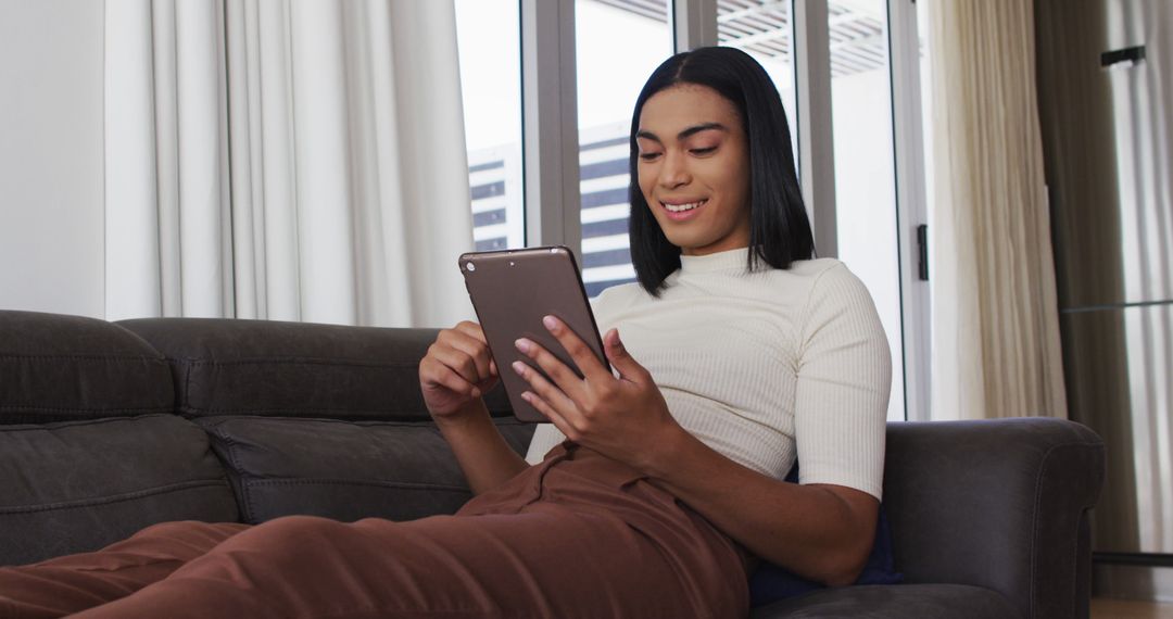 Woman Relaxing on Sofa with Digital Tablet at Home - Free Images, Stock Photos and Pictures on Pikwizard.com