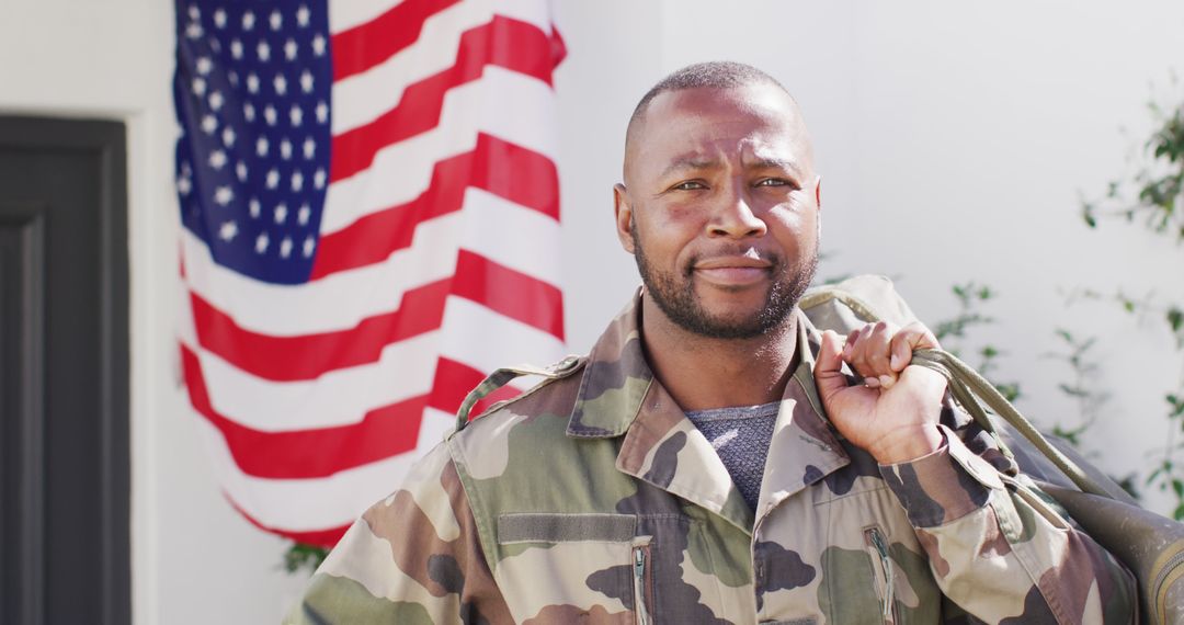 Portrait of happy african american male soldier holding bag with flag of usa in the background - Free Images, Stock Photos and Pictures on Pikwizard.com